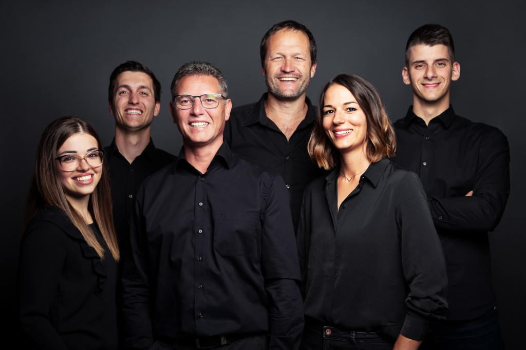 Teamfoto vor schwarzem Hintergrund