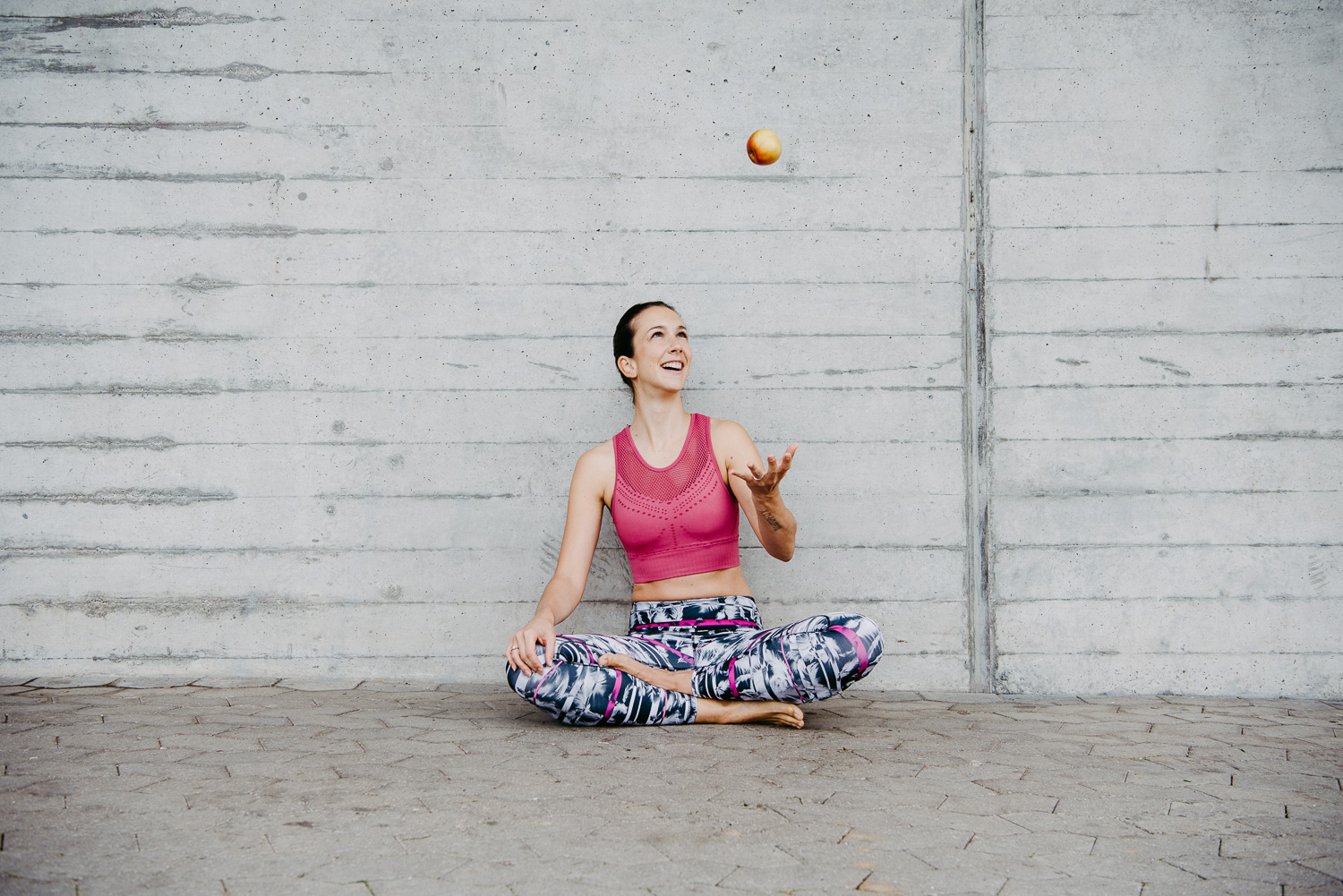 Fitnesstrainerin Sandra Cerrisi wirft Apfel in die Luft